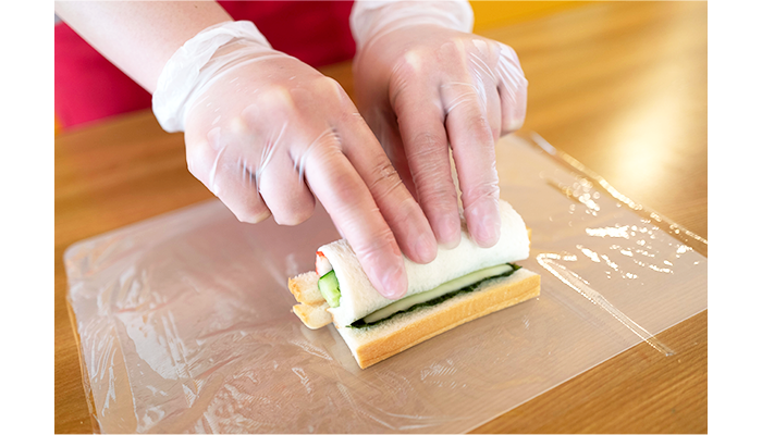 両手をチョキにして、人差し指と中指で食パンの端を押さえながら、残りの指を使って巻いていきます。